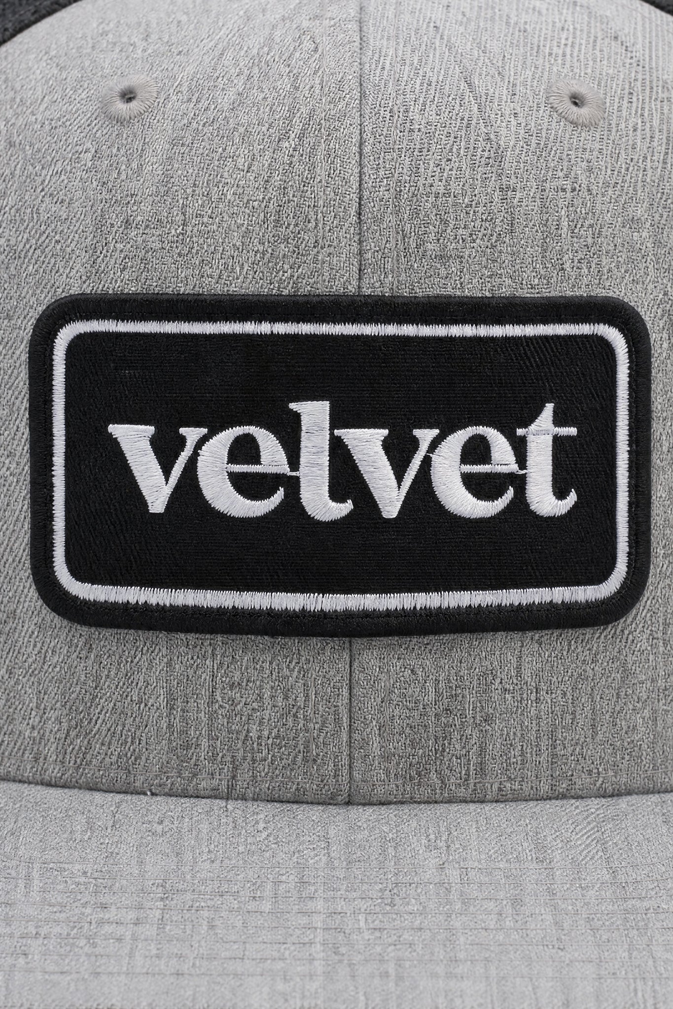 Gray cap with a black patch displaying the word 'velvet'.