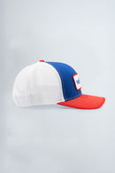 Trucker hat with white front, blue side, and red brim on a light gray background