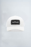 White cap with 'velvet' logo on a light background