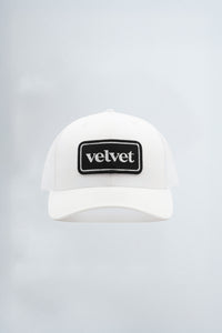White cap with 'velvet' logo on a light background