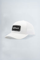 White cap with a black patch on a gray background