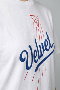 White t-shirt with blue and red 'Velvet' logo on a plain background