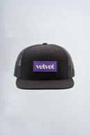 Black cap with a purple logo on a light  background