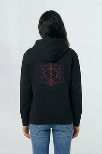 Person wearing a black hoodie with a geometric design on the back against a light background