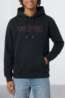 Person wearing a black hoodie with 'velvet' text on a light background