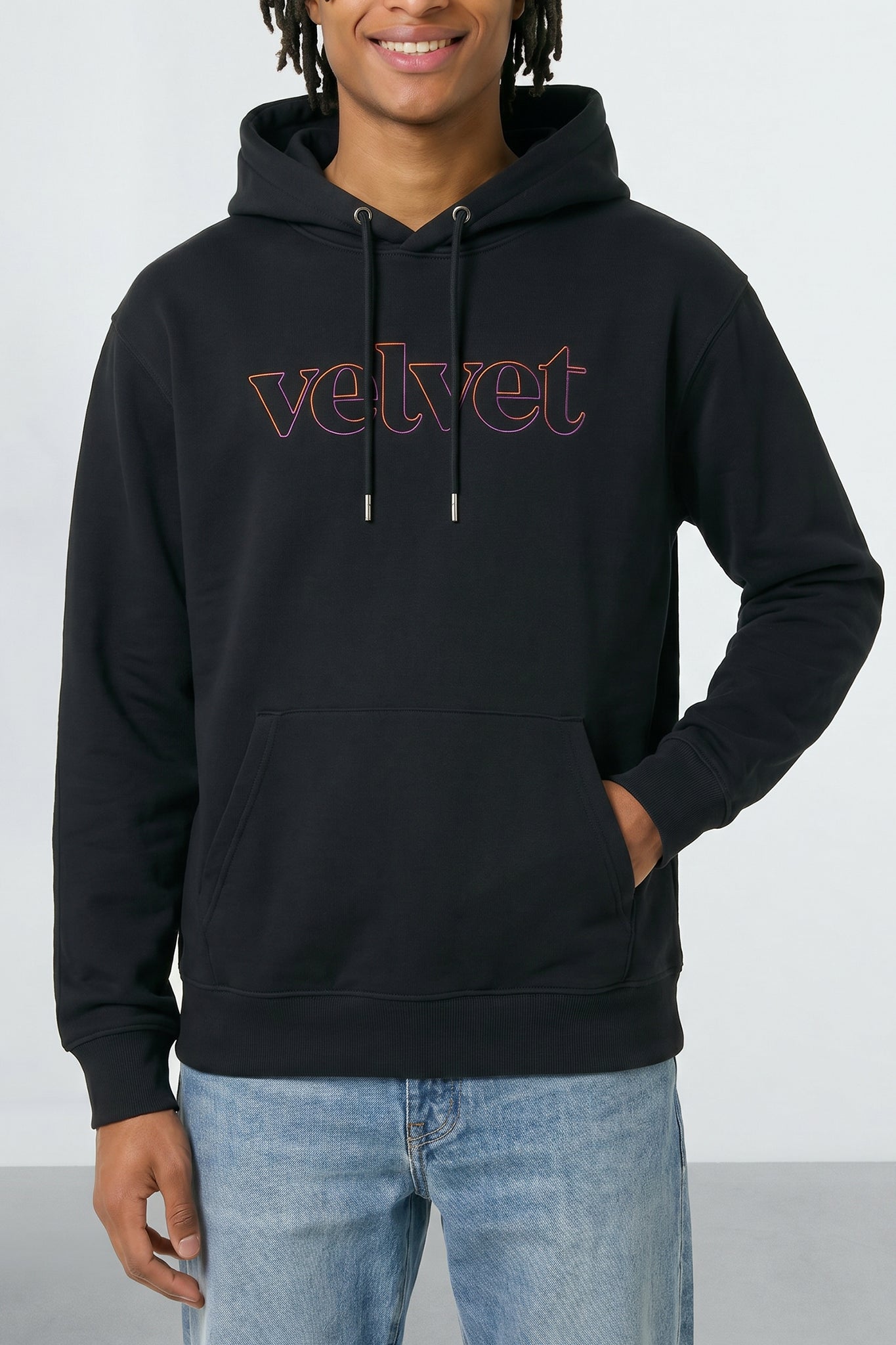 Person wearing a black hoodie with 'velvet' text on a light background