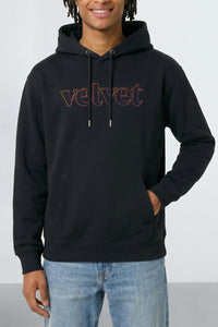 Person wearing a black hoodie with 'velvet' text on a light background