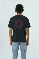 Person wearing a black t-shirt with a geometric design on the back, standing against a light background.
