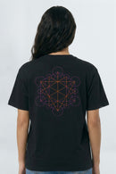 Person wearing a black t-shirt with a geometric design on the back against a light background