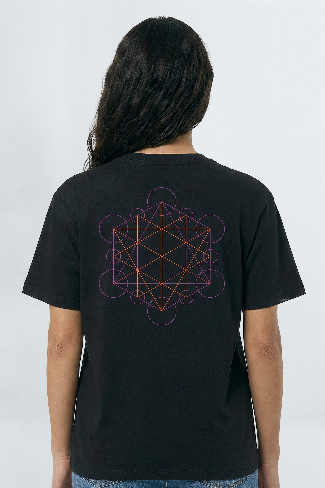 Person wearing a black t-shirt with a geometric design on the back against a light background