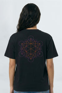 Person wearing a black t-shirt with a geometric design on the back against a light background