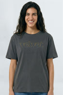 Person wearing a gray t-shirt with 'velvet' text on a light background