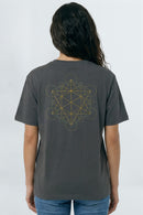 Person wearing a gray t-shirt with a geometric design on the back against a background