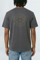 Person wearing a gray t-shirt with a geometric design on the back, standing against a light background.
