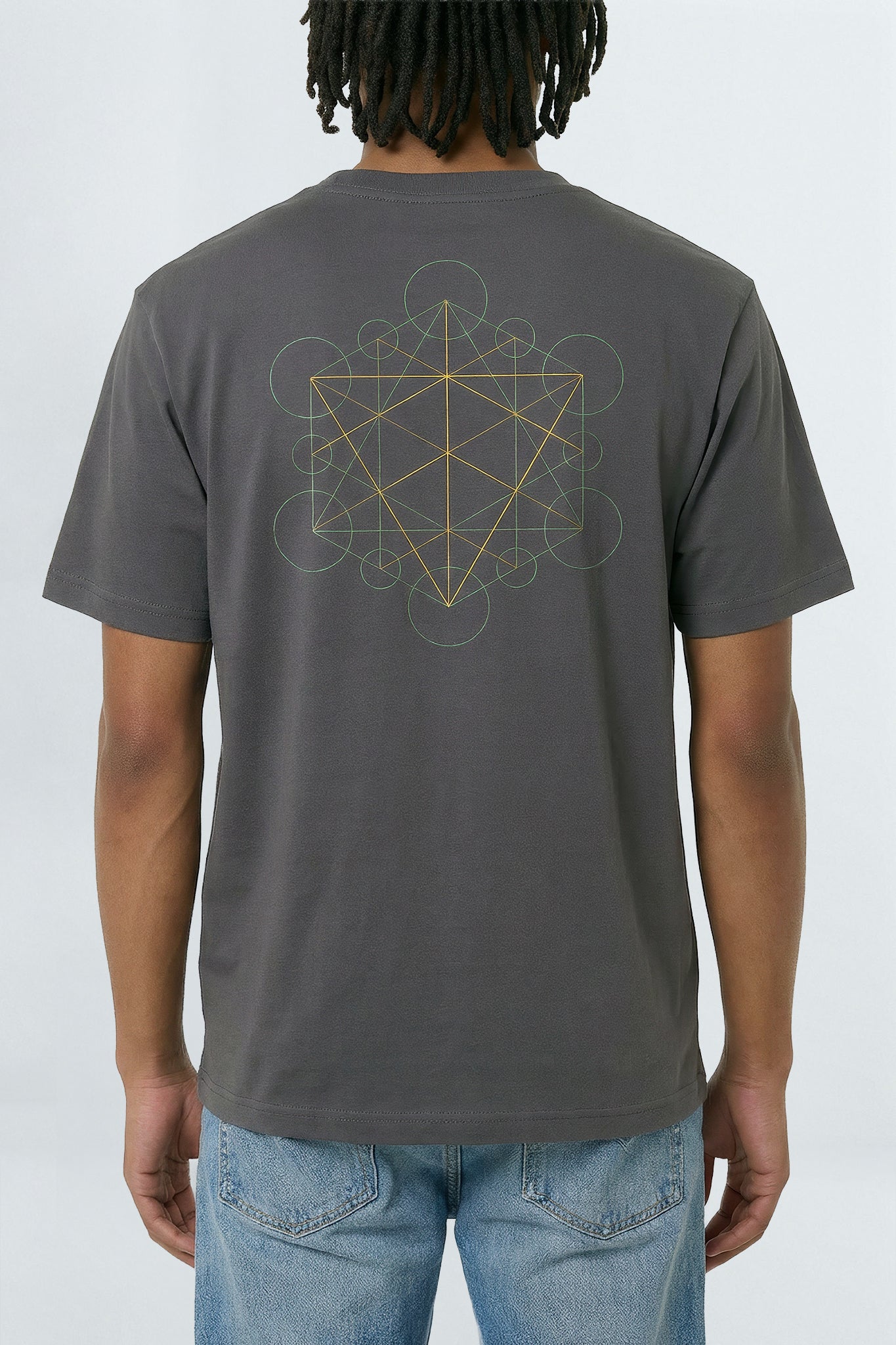 Person wearing a gray t-shirt with a geometric design on the back, standing against a light background.