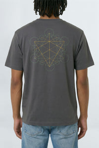 Person wearing a gray t-shirt with a geometric design on the back, standing against a light background.