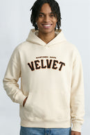 Person wearing a  cream hoodie with text on a light background