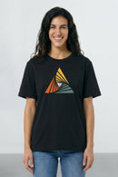 Person wearing a black t-shirt with a colorful triangle design on a plain background
