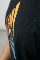 Black t-shirt with a colorful butterfly design on a plain background