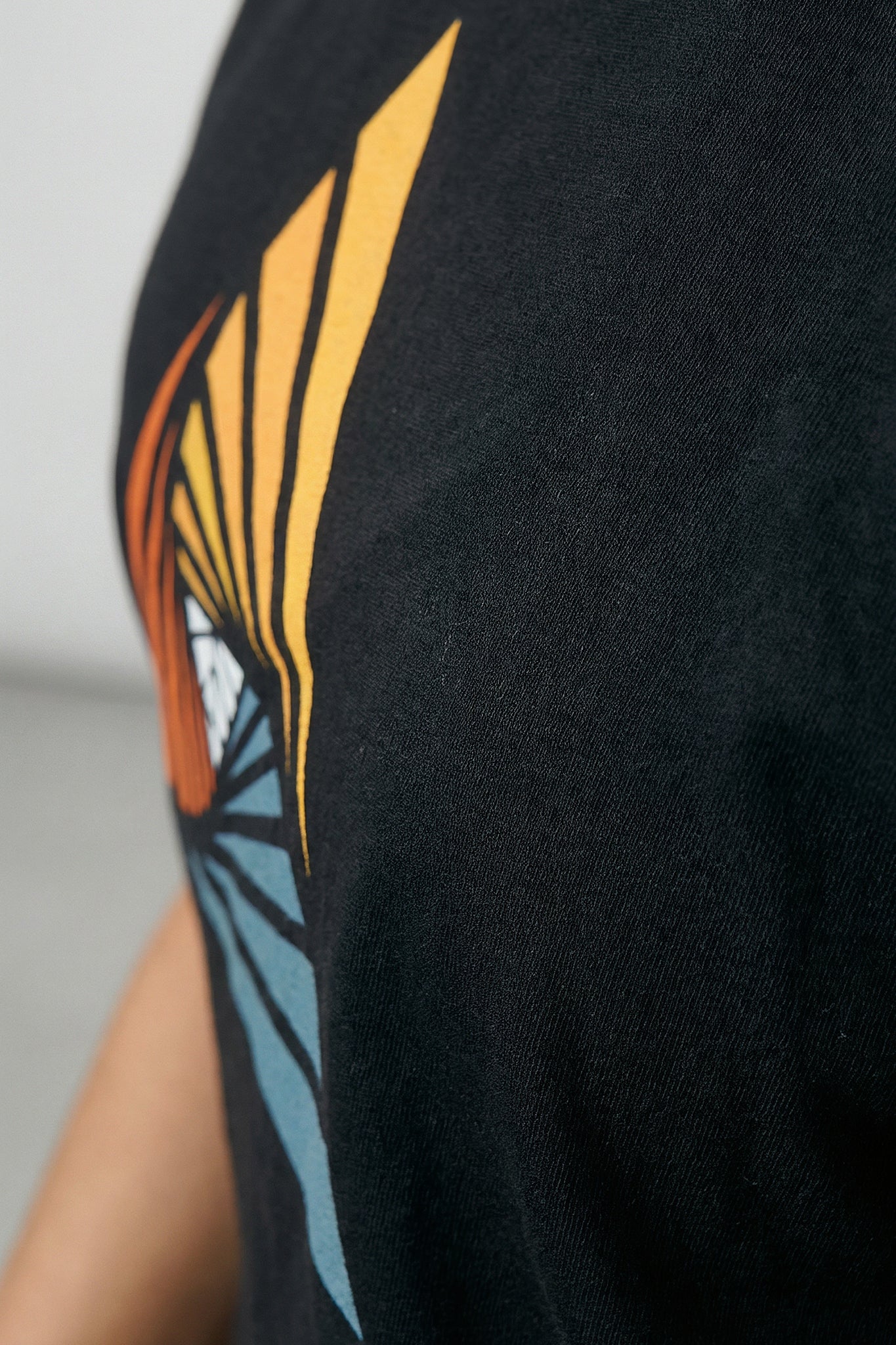 Black t-shirt with a colorful butterfly design on a plain background