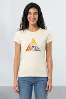 Woman wearing a beige t-shirt with a colorful triangle design on a plain background