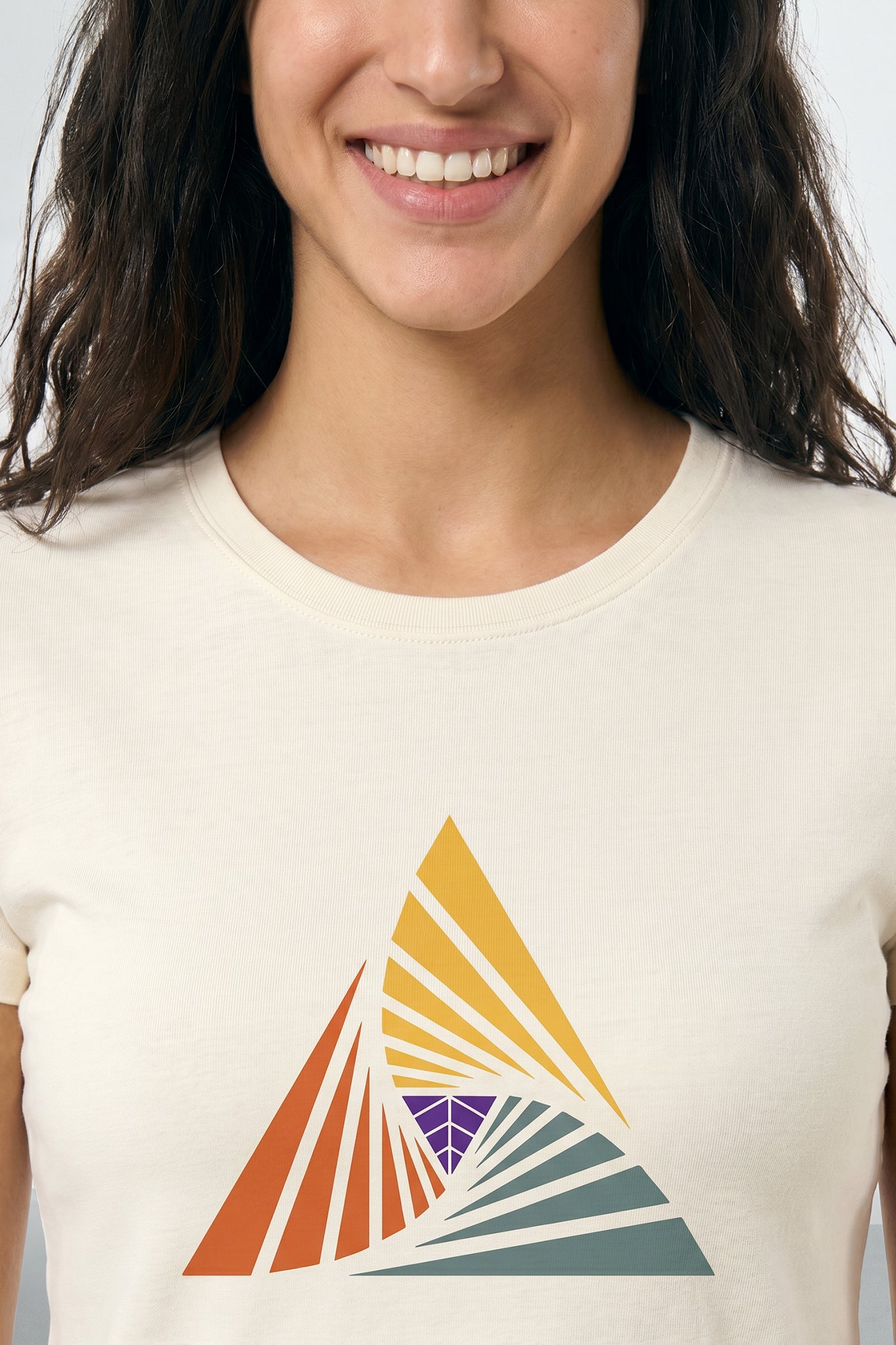 Person wearing a beige t-shirt with a colorful triangle design