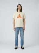 Person wearing a beige t-shirt with a geometric design and blue jeans on a light background