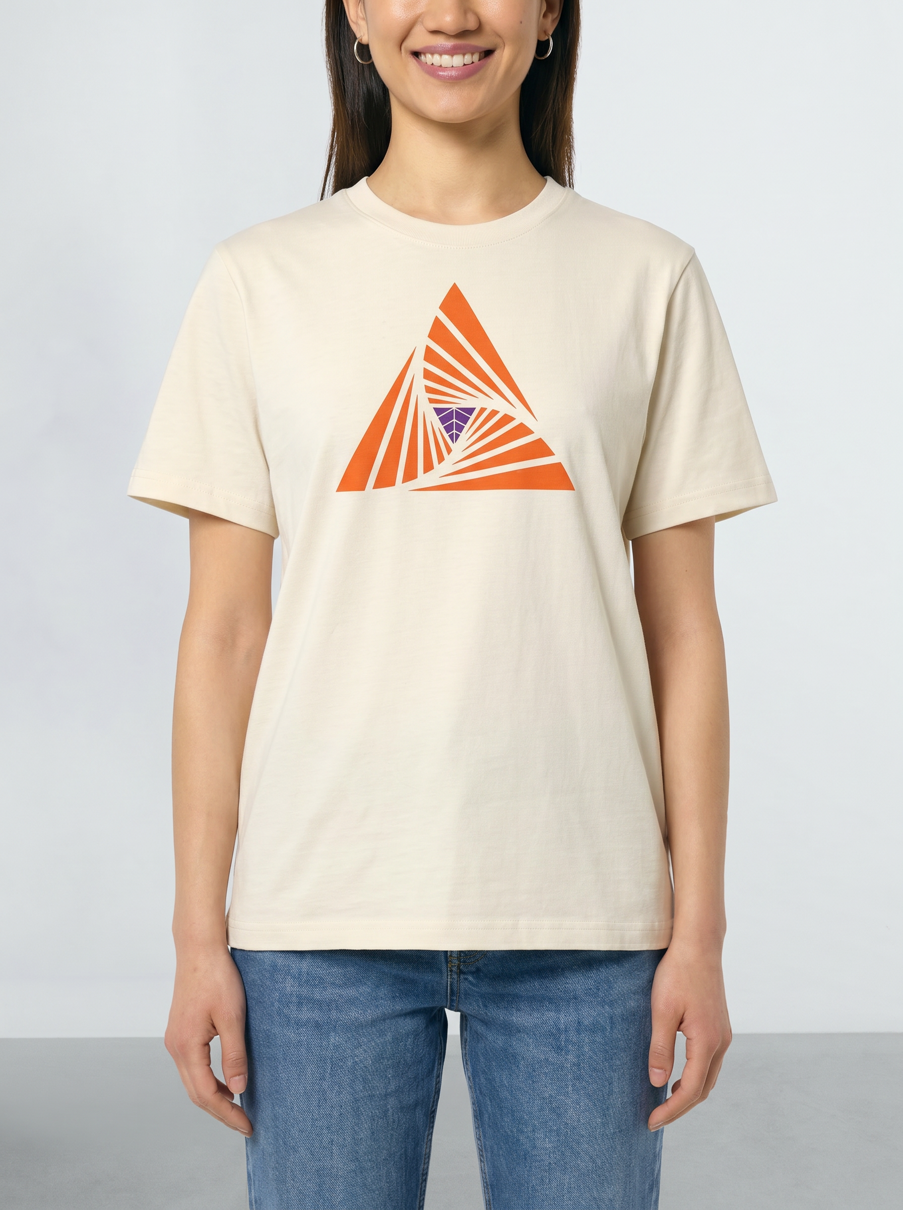 Person wearing a beige t-shirt with an orange geometric design on a plain background